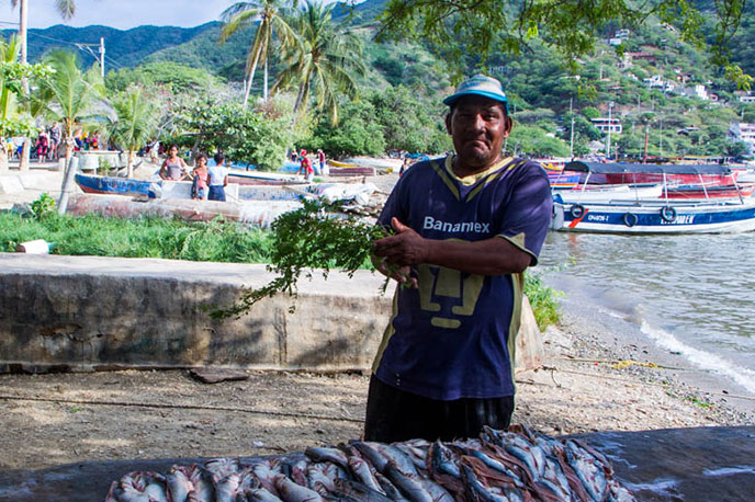 A fisherman posing next to his catch.