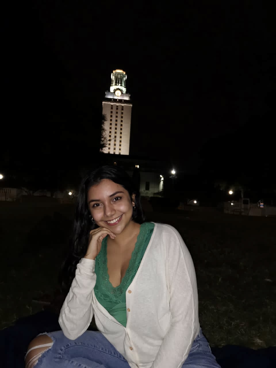 woman smiles near tower at night