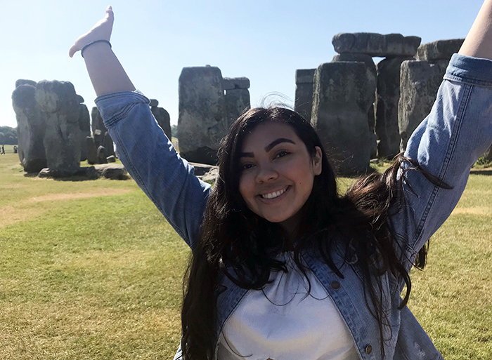 Brianna Rodriguez putting her hands up in front of the stonehenge