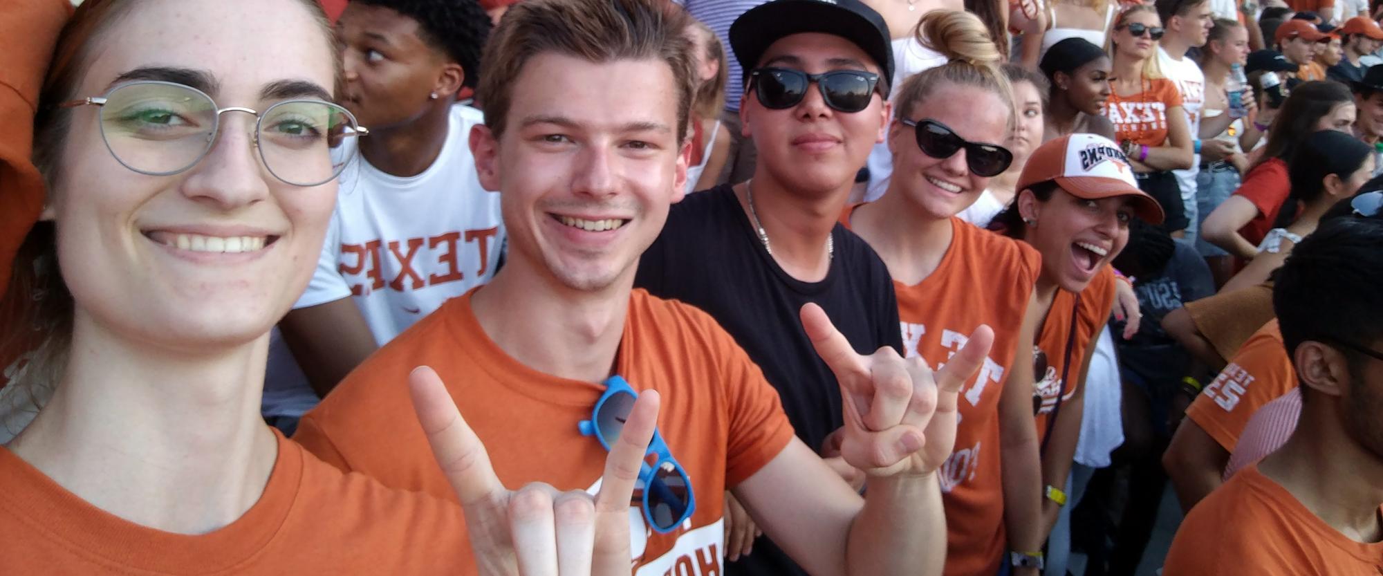 chris hahn poses with friends at a football game