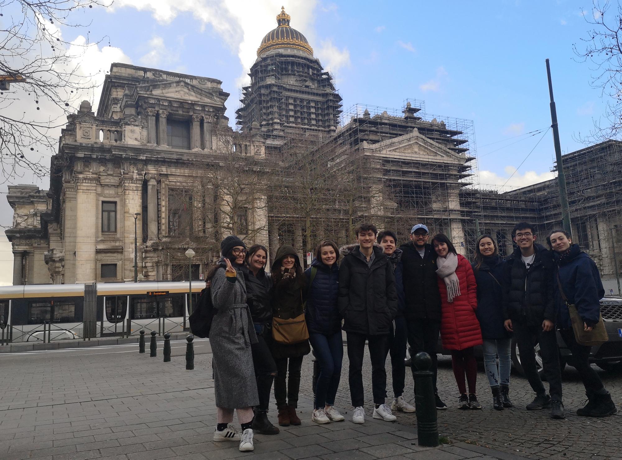 Frances Garnett poses in front of large historic building with group of students