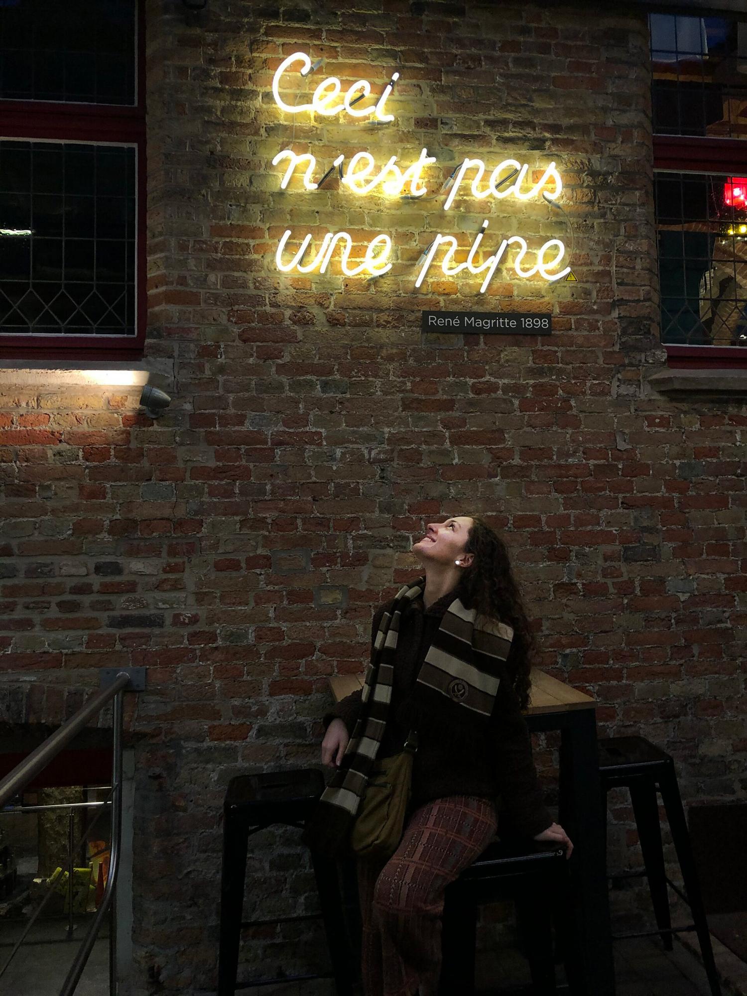 frances sits at a cafe in belgium at night