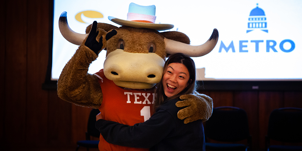 A student poses with surprise guest Hook 'Em 