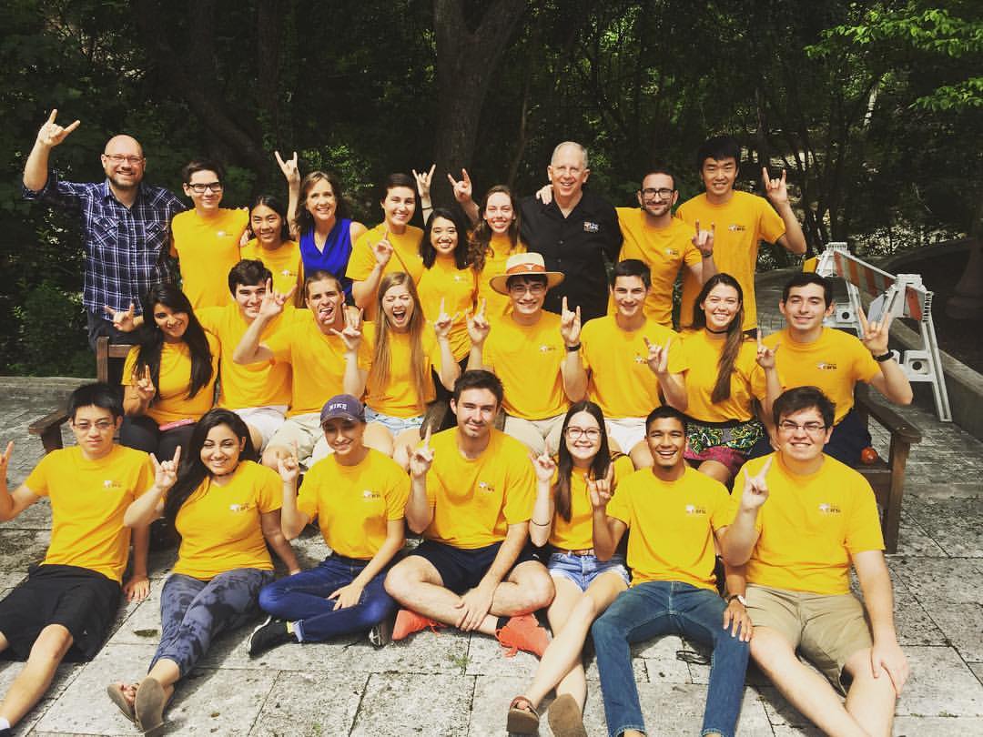 Group photo where Himchand Persad appears with engineering students and faculty. They are wearing matching t-shirts. Everyone is doing the hook 'em sign.
