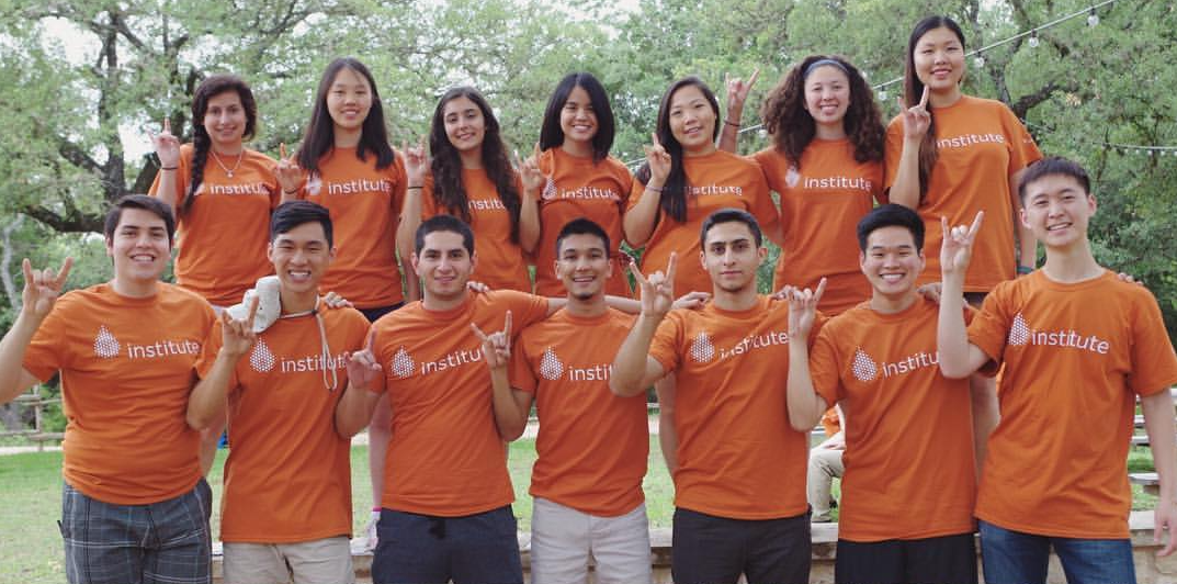 Group photo where Himchand Persad appears with students from an organization. They are doing the hook 'em sign.