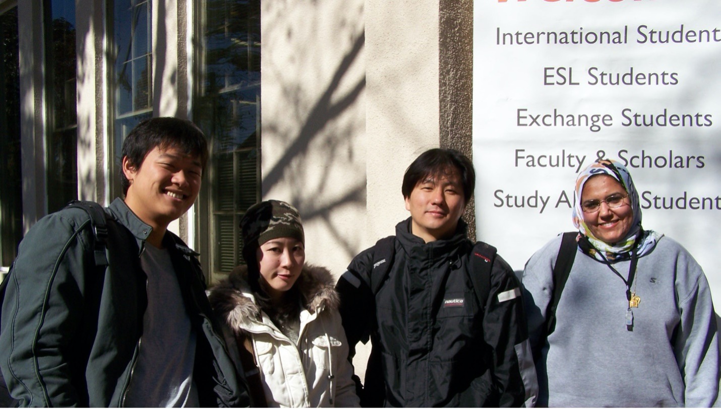 a group of four people stand in front of a building 