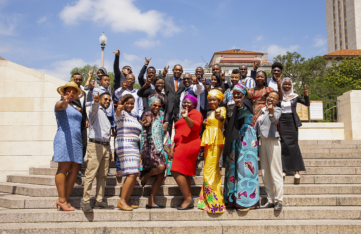 YALI fellows in front of the UT tower doing a Hook 'em horns