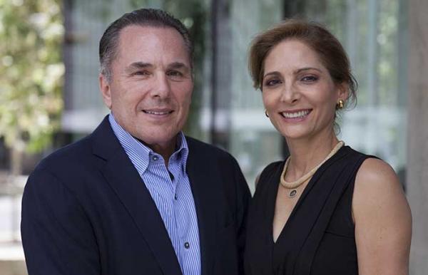 Carlos and Clara Quintanilla pose together in front of a UT building