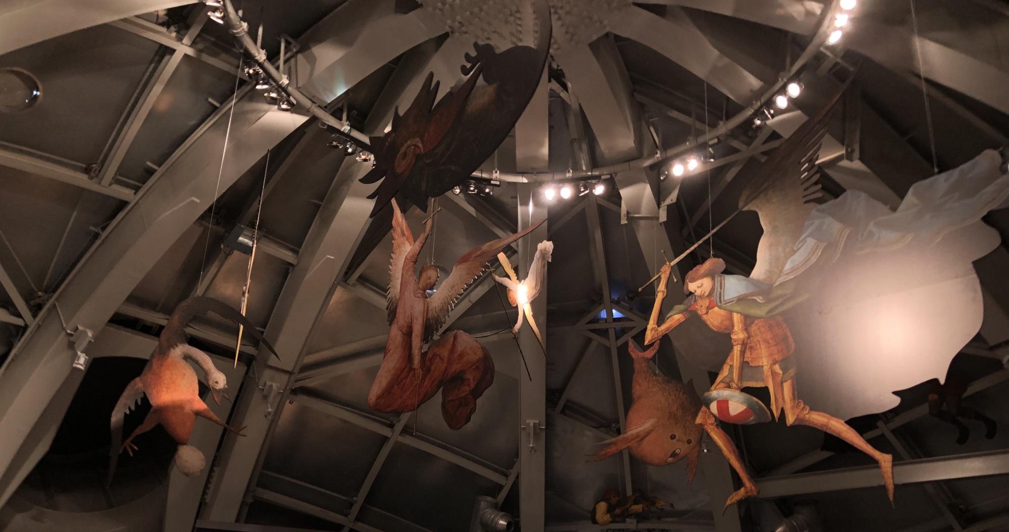 A hanging exhibit of various European mythical creatures cardboard cutouts