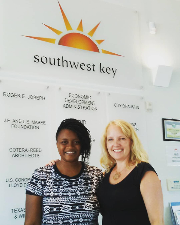 Madzima and Fry smiling in front of Southwest Key sign