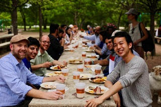 English Language Center students and instructors share a meal outside at picnic table.