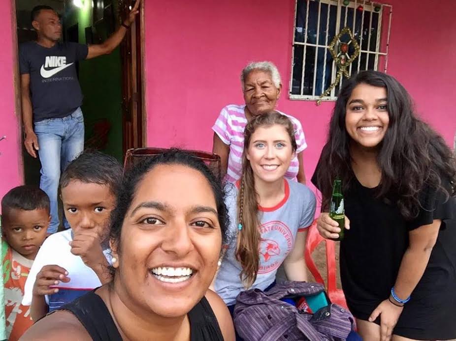 Selfie of Nakita with another volunteer and community members 
