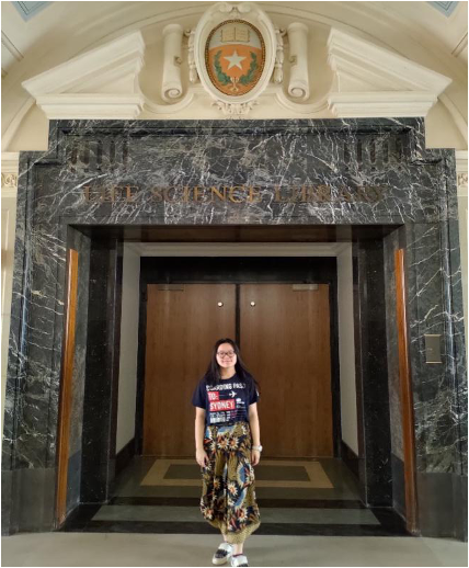 girl stands in front of large doors 