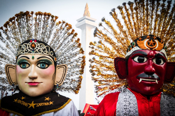 two colorful busts with large headdresses side by side during daytime