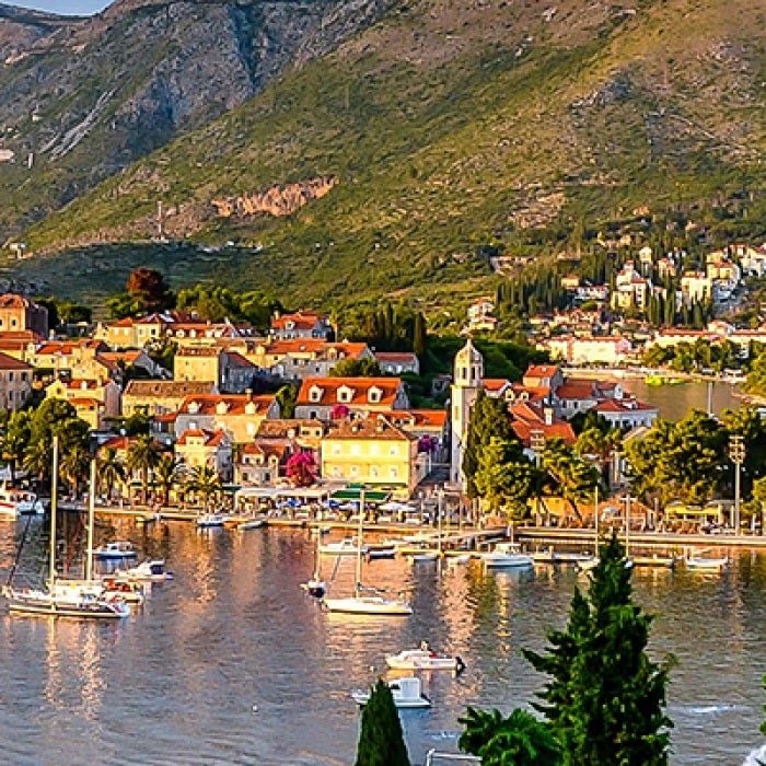 Croatia town with boats in water and green trees and mountains