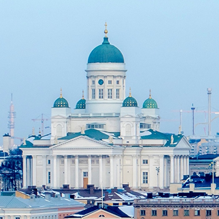 Finland cathedral with blue roof surrounded by small buildings and clear sky