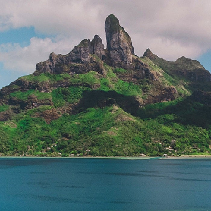 Tropical island mountain by water in French Polynesia