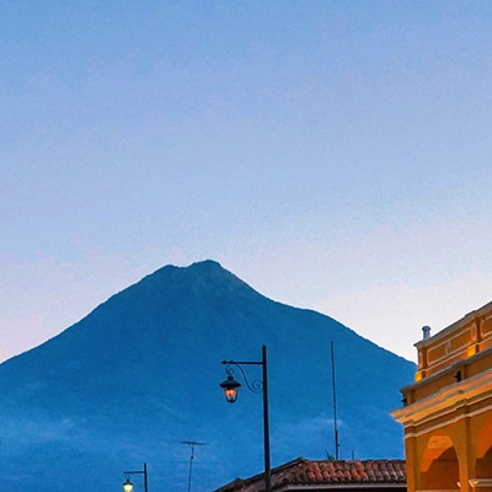 Guatamala underlit buildings at night with mountain in the background