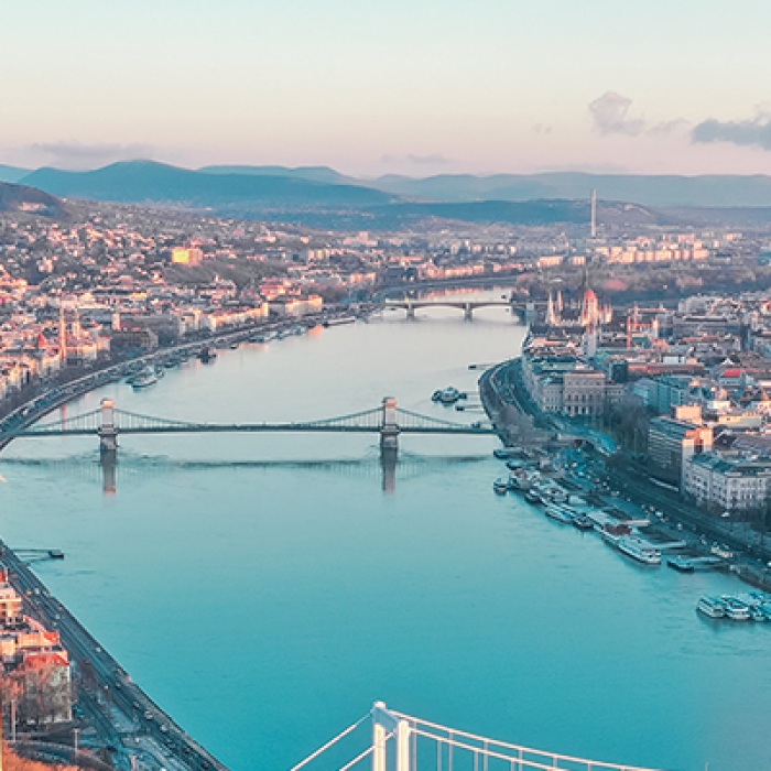 Hungarian city divided by river with bridge in center