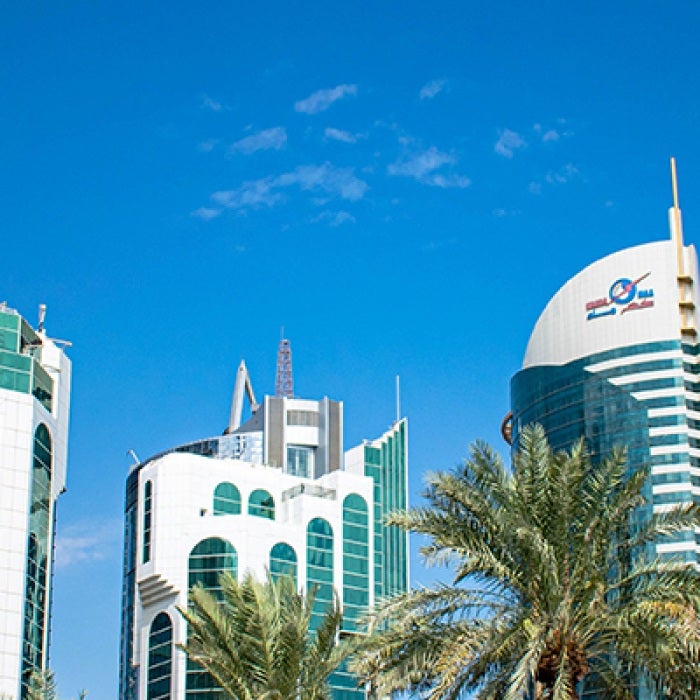 Qatar blue sky with tall buildings and palm trees