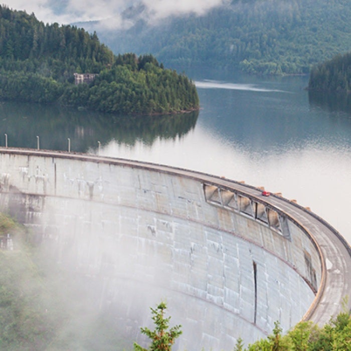 Romanian lake with curvy road above and forests