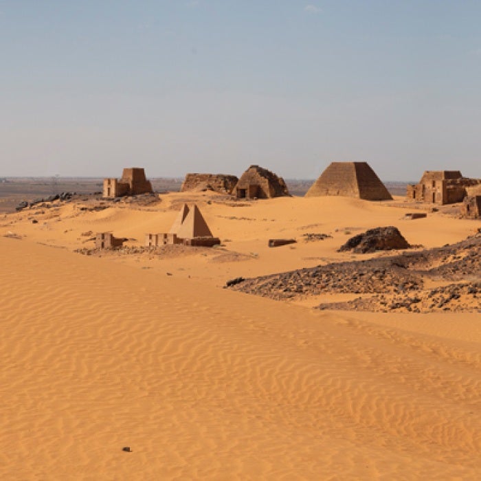 Desert in Sudan with pyramid-like structures and stones on the ground
