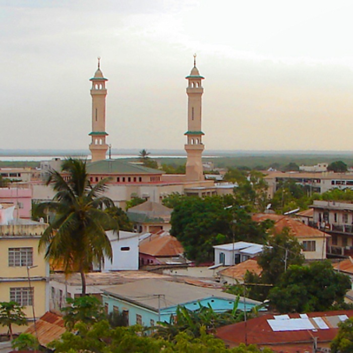 the Gambia houses and trees in the city with two towers in the background