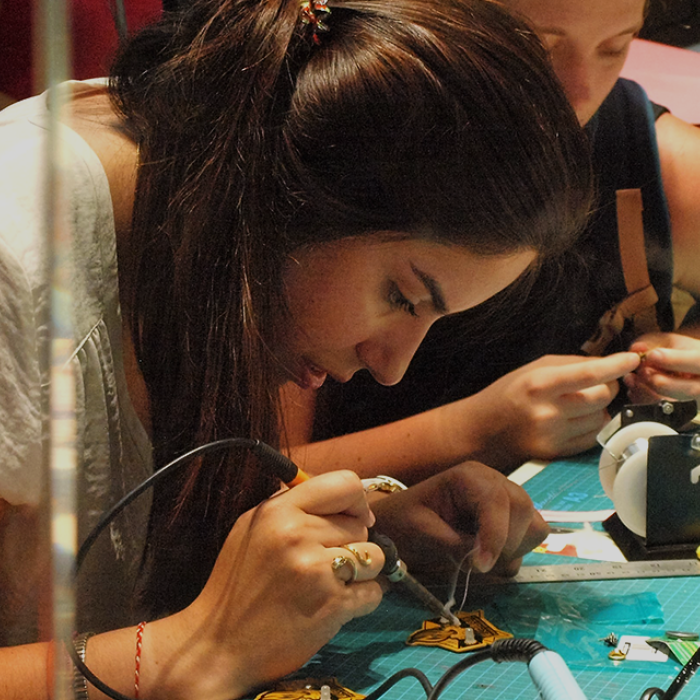 Student leaning over working on precise manual project.