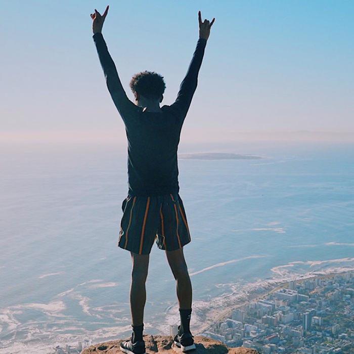 Person standing on top of mountain facing beautiful view in South Africa.