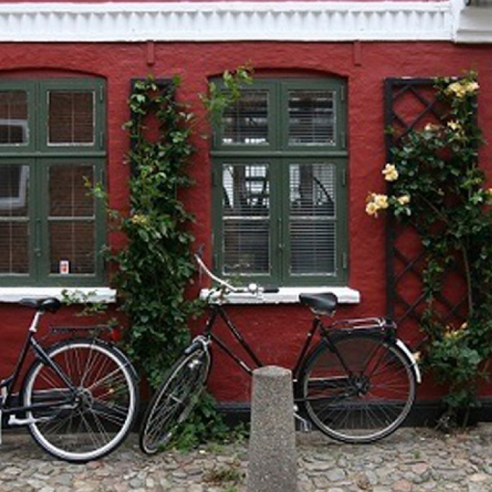 Bicycles parked outside of a red building.