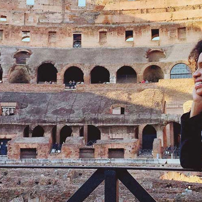 A woman smile while gazing inside the Roman Colosseum.