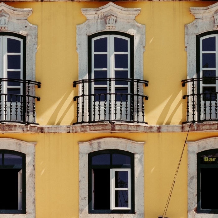 two rows of french doors on yellow building 