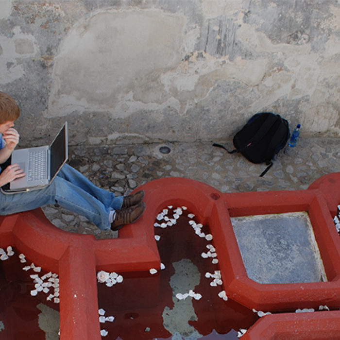 student on laptopo sitting near art display