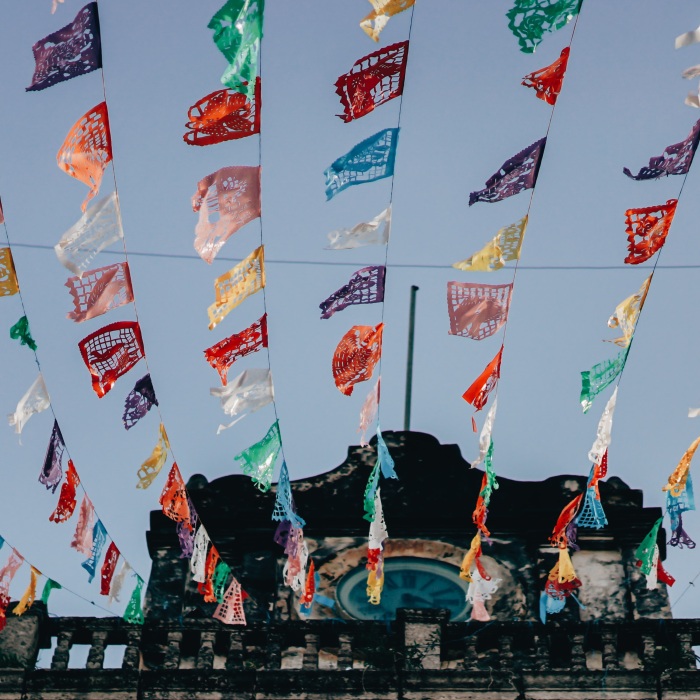 low angle photo of temple with rows of colourful square pendant flags 
