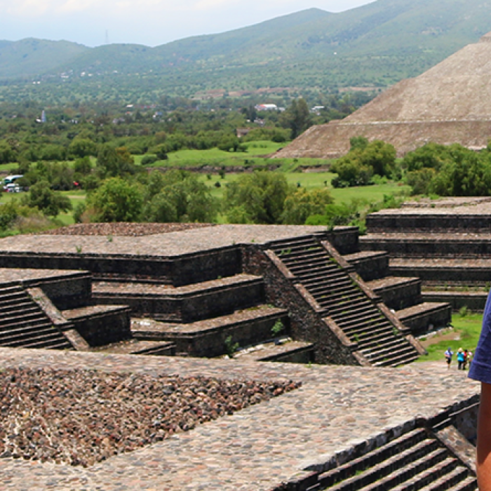 Student wearing a Texas Global T-shirt in front of pyramids in Mexico