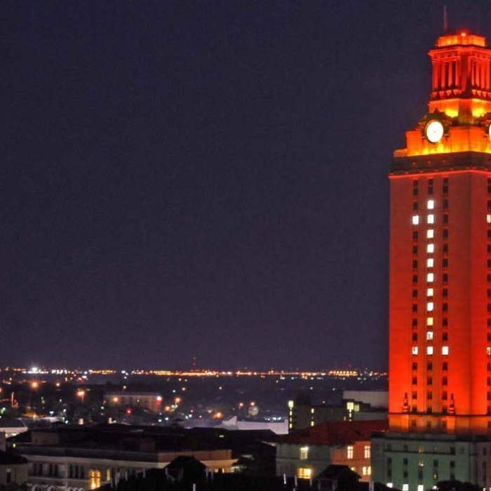 UT Austin tower lit up orange with No. 1 above Austin cityscape 
