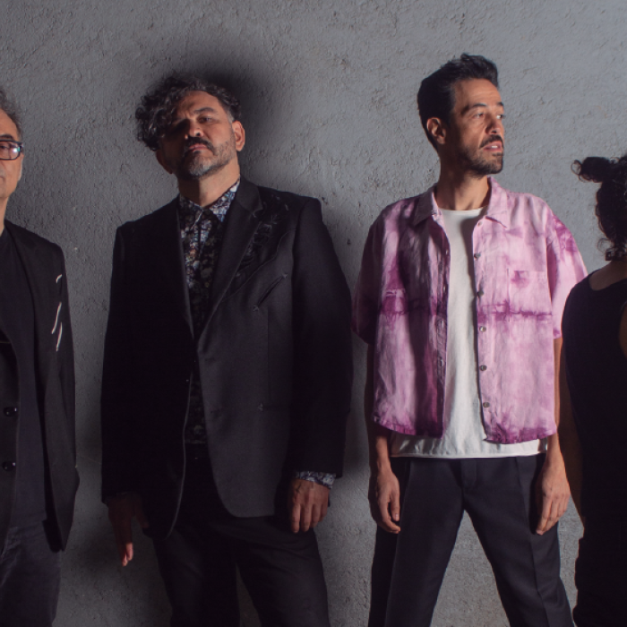 Café Tacvba return to Austin with special guests Diamante Eléctrico posing against grey wall