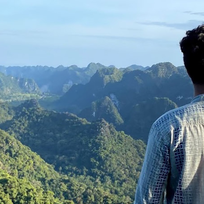 An ethnic young man looks out over the mountainous countryside of Singapore in Southeast Asia