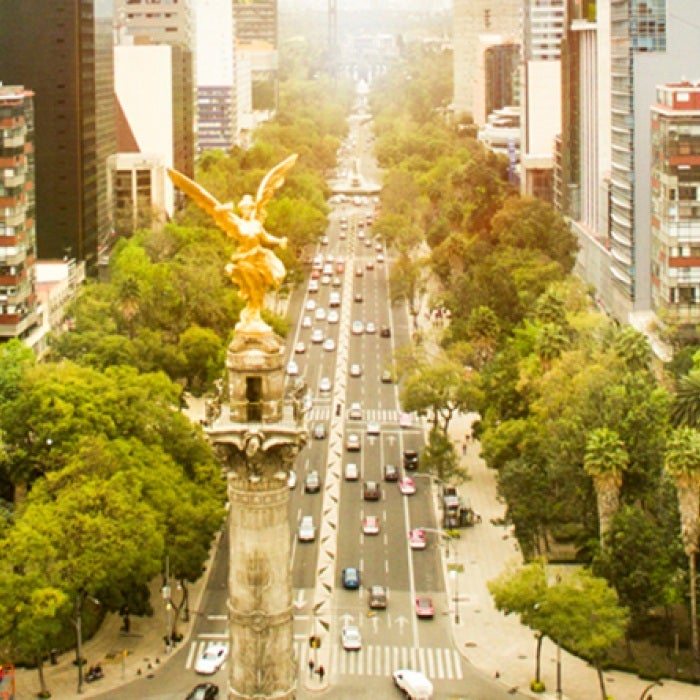 Aerial shot of buildings and statues along a large boulevard in Mexico City