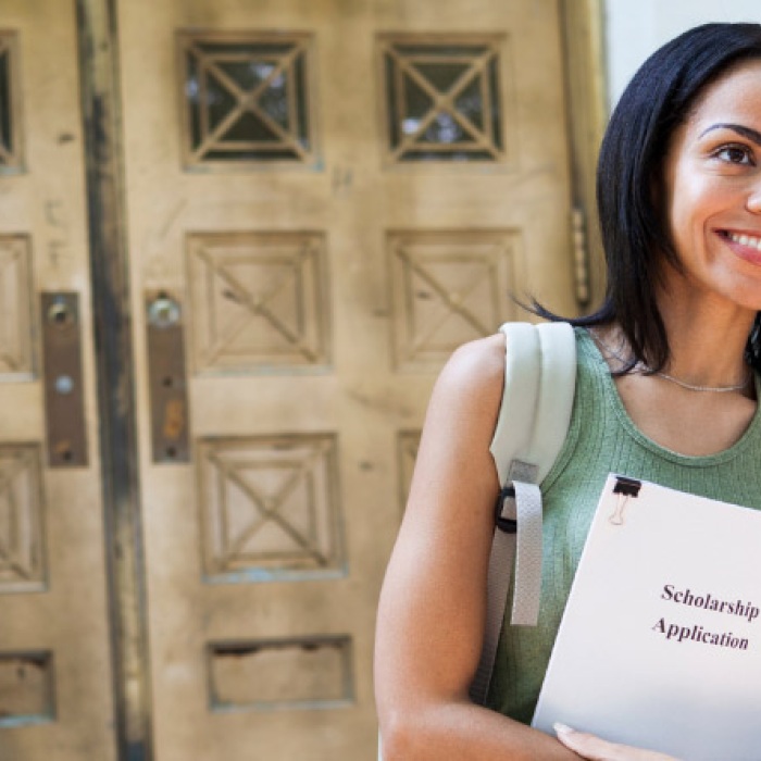 prospective female student looking full of hope with scholarship application folder