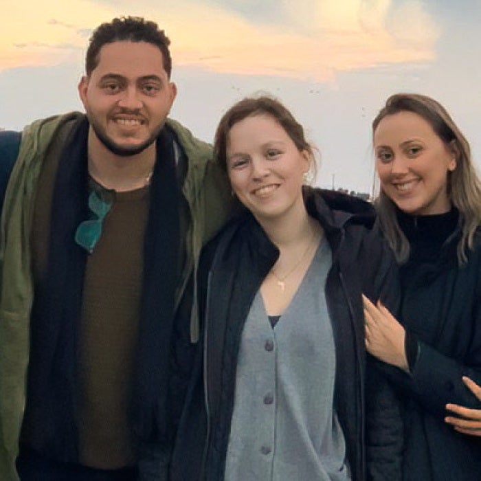 A diverse group of students posing for photo with a beautiful sunset and the city of Jerusalem, Israel in the background