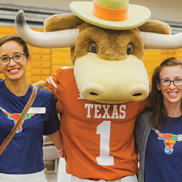 Diverse UT students showing longhorn pride in group photo with mascot