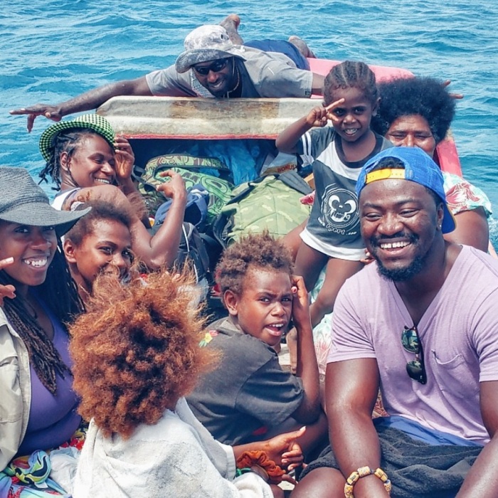 Peace Corps Volunteer on a boat in Vanuatu with several local community members.