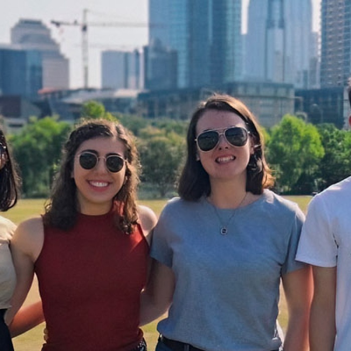 Students stand in front of the Austin city skyline