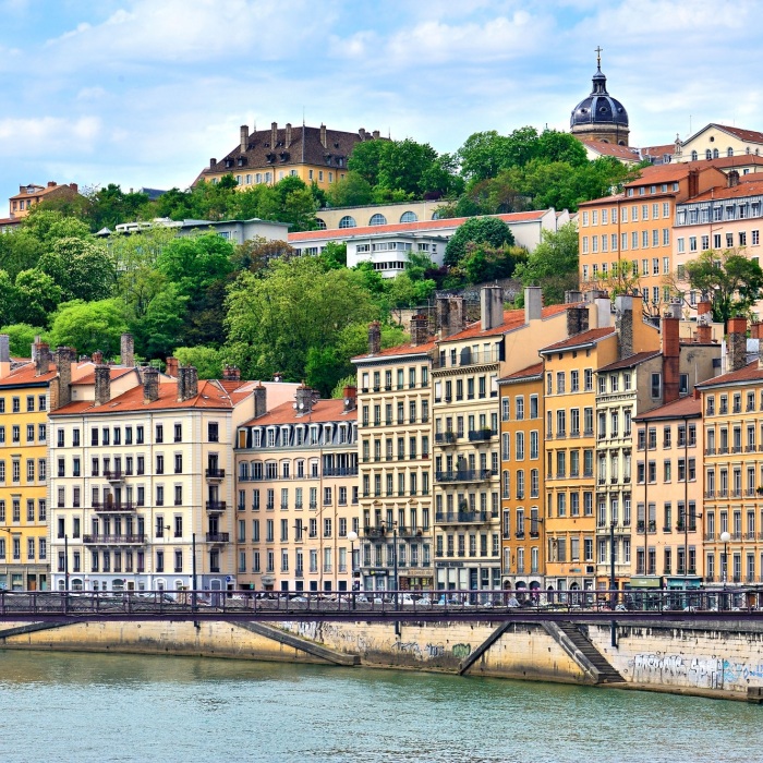 Colorful buildings with red roofs along boardwalk in Lyon, France