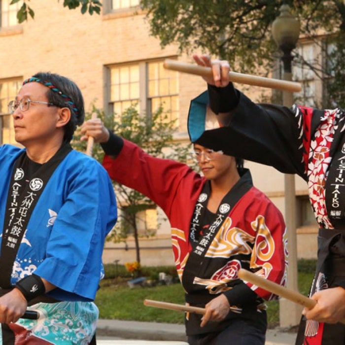 Performers play drums in a traditional Southeast Asian clothing