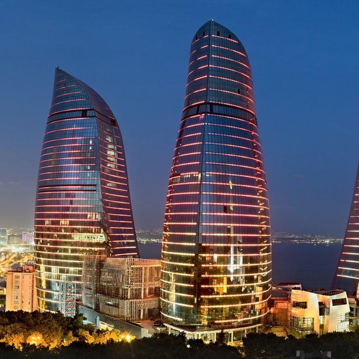 Baku Flame Towers towering above the illuminated city at night, Azerbaijan