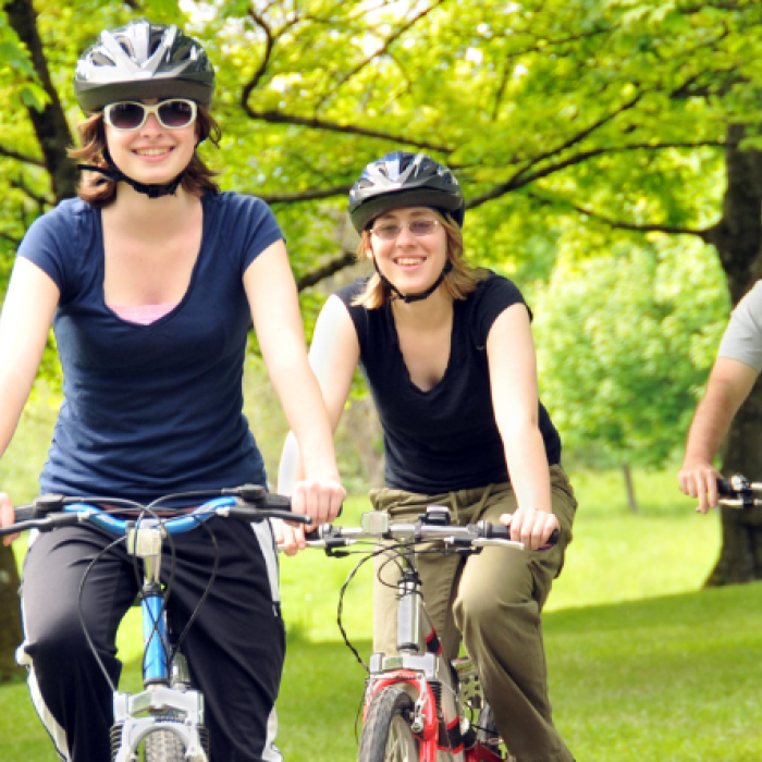 Three people riding bicycles in the park