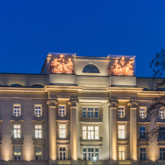 large yellow building with many windows and a clear blue sky in the background