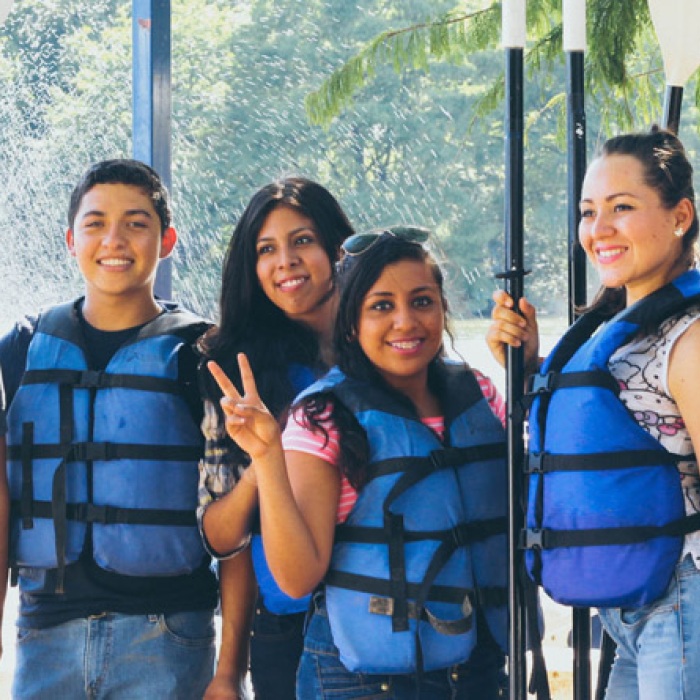 ELC students smiling and holding kayak oars as they pose for a group photo at Barton Springs